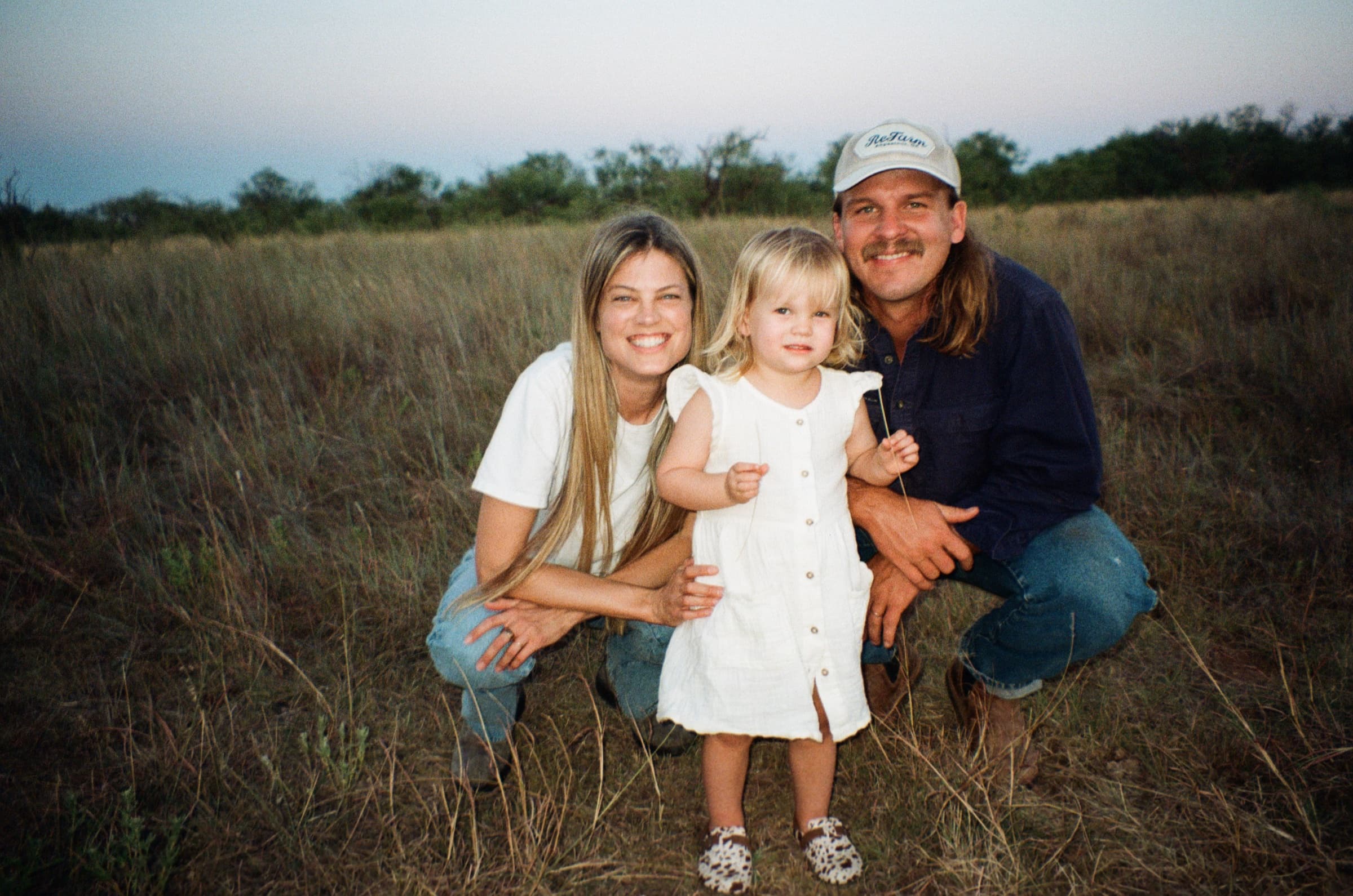 The Scherler-Abney family standing together in native grass